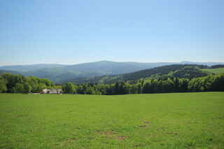 Býv. Velký Babylon. Vzadu uprostřed je vidět Huťská hora (1187 m n.m.), vpravo hora Sokol/Antýgl (1253 m n.m.)