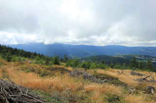 Vlevo je zahalena Jezerní hora (1344 m n.m.) se Svarohem (1334 m n.m.), vpravo vrchol hory Ostrý (1293 m n.m.)