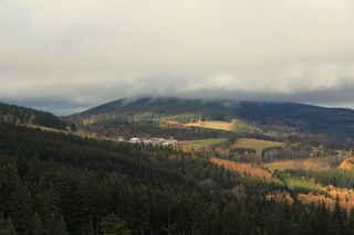 Mlhou zahalený vrchol kopce Plošina (972 m n.m.), pod ním vesnice Šukačka